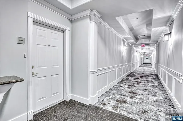 a view of a hallway with wooden floor and entryway