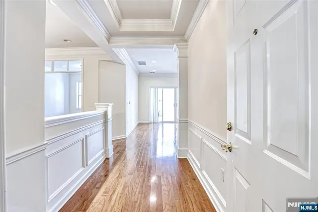 a view of a hallway with wooden floor and staircase