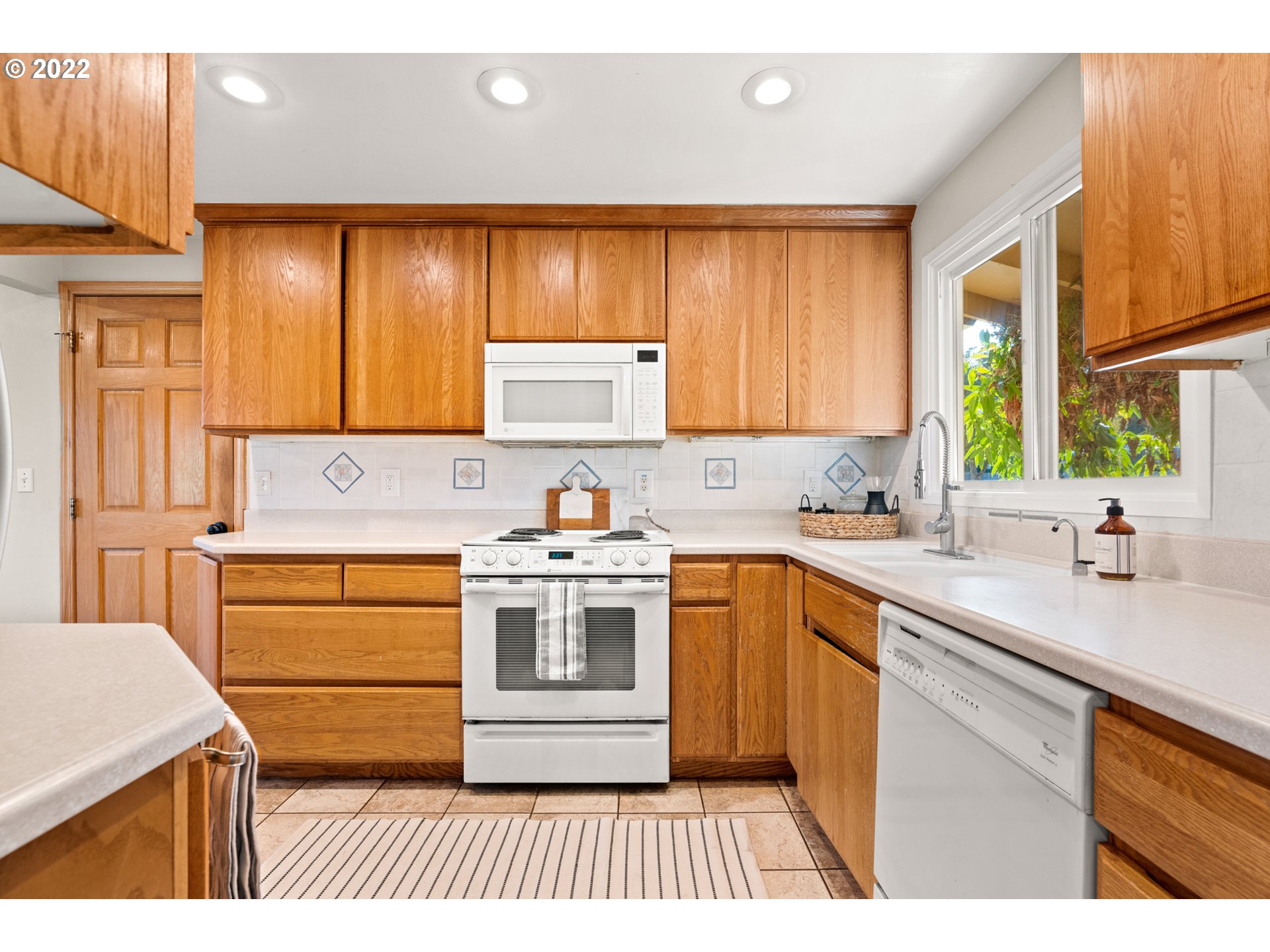 6920 Southwest Briarcliff Circle Beaverton, OR 97008 - Photo 12 of 32 a kitchen with a sink stove and cabinets