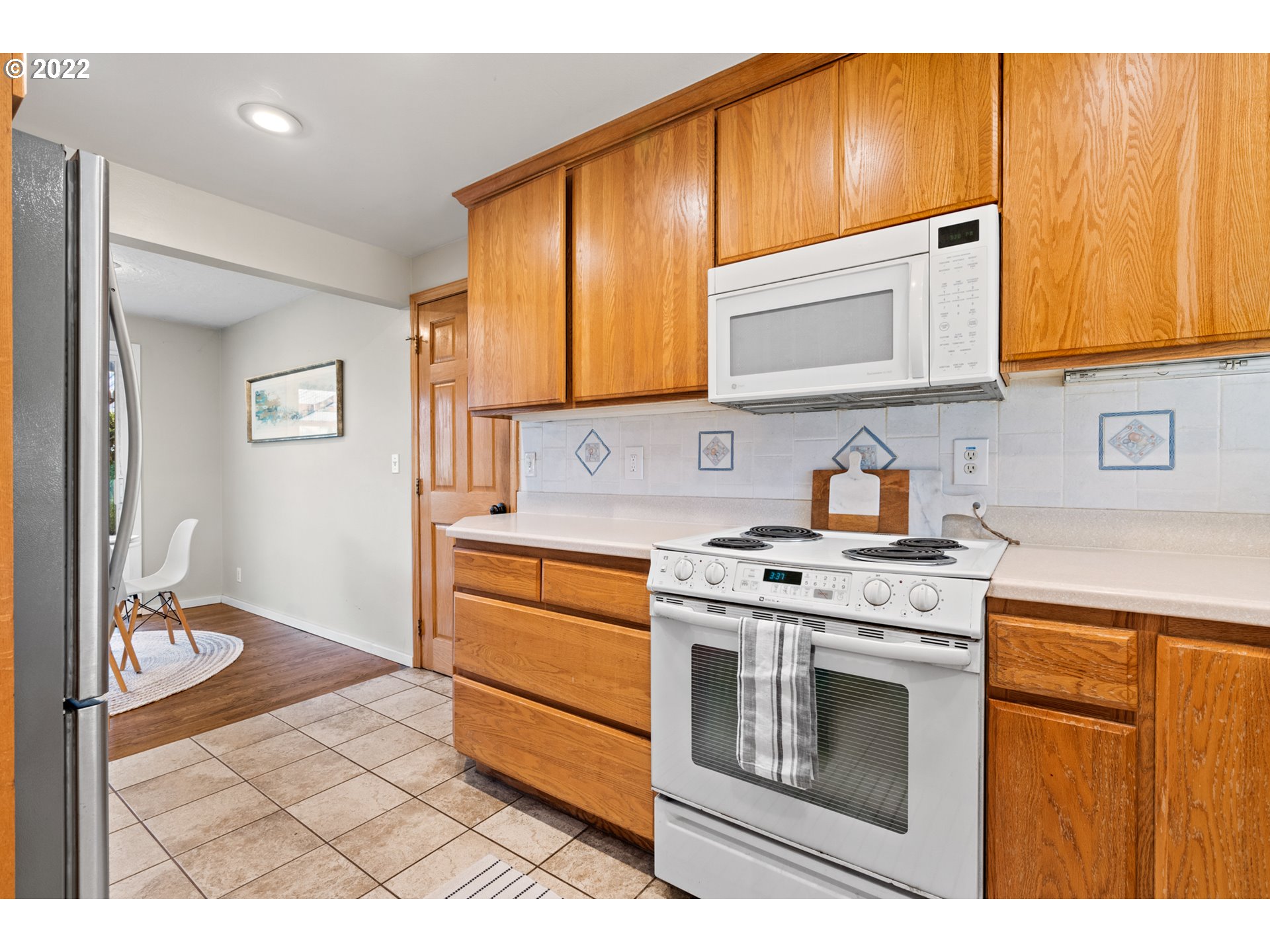 6920 Southwest Briarcliff Circle Beaverton, OR 97008 - Photo 13 of 32 a kitchen with stainless steel appliances granite countertop a stove a sink and a microwave