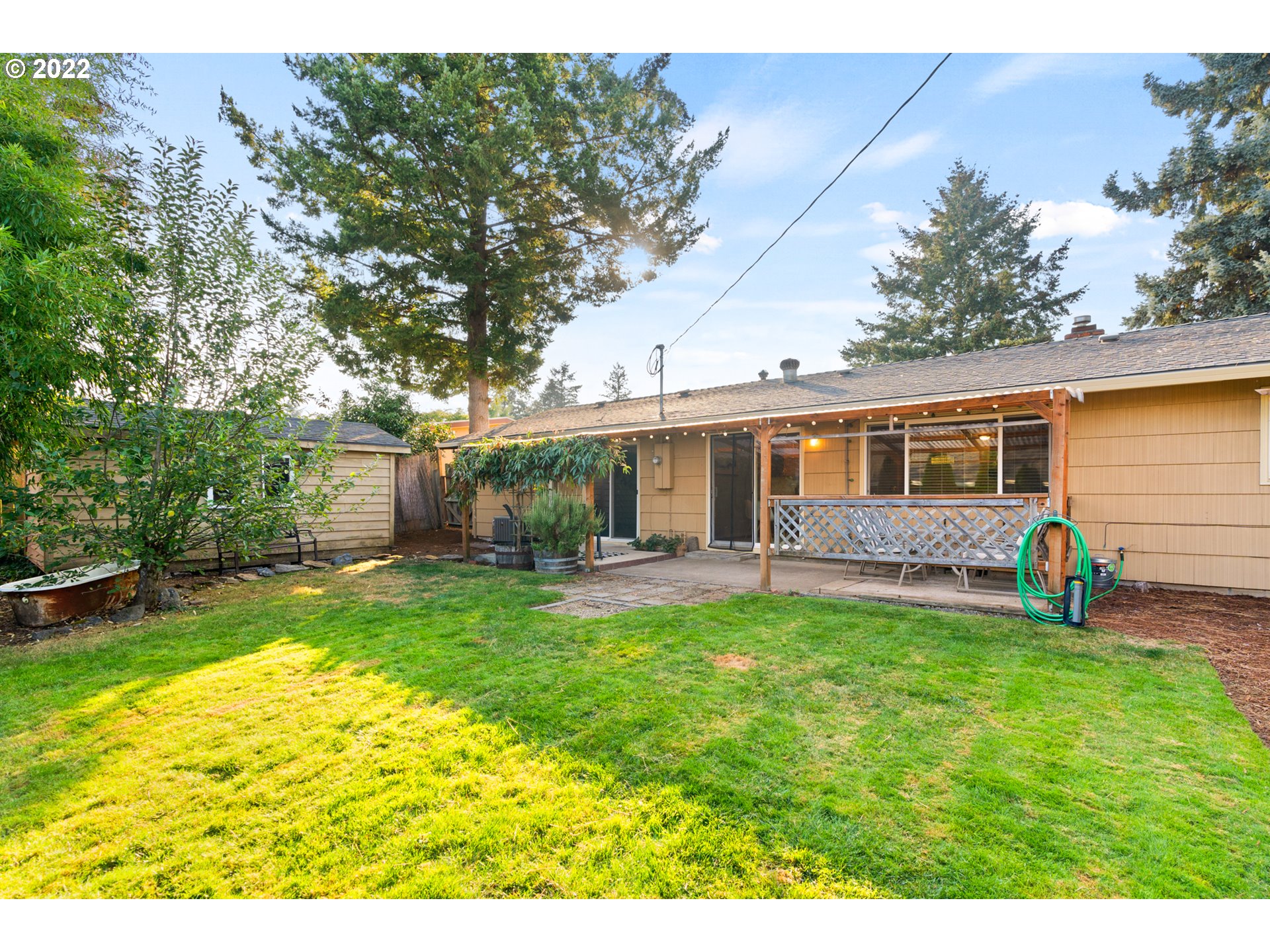6920 Southwest Briarcliff Circle Beaverton, OR 97008 - Photo 31 of 32 a view of a house with a backyard and a patio