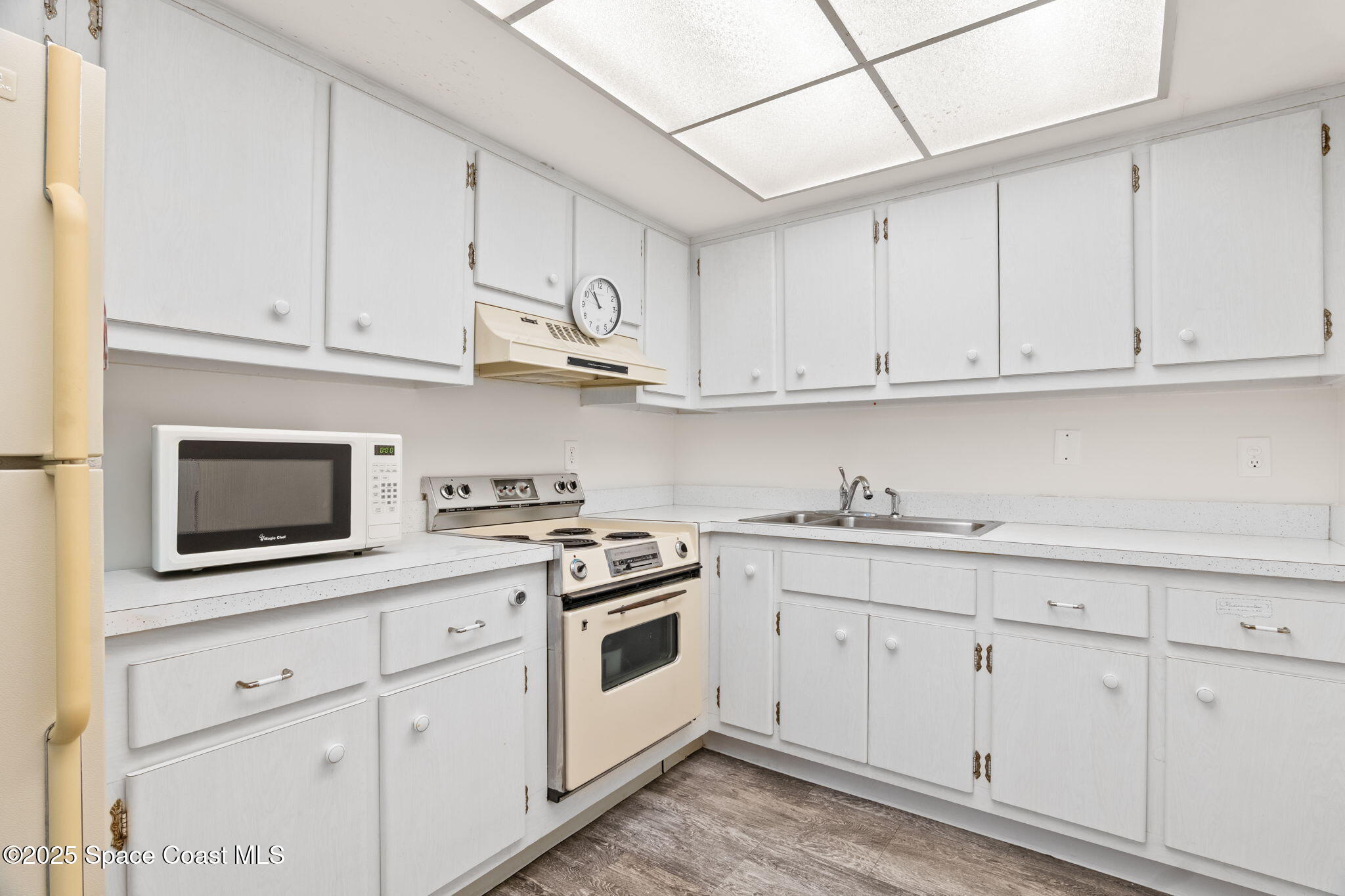 221 Columbia Drive, Unit 343 Cape Canaveral, FL 32920 - Photo 12 of 22 a kitchen with white cabinets and white appliances