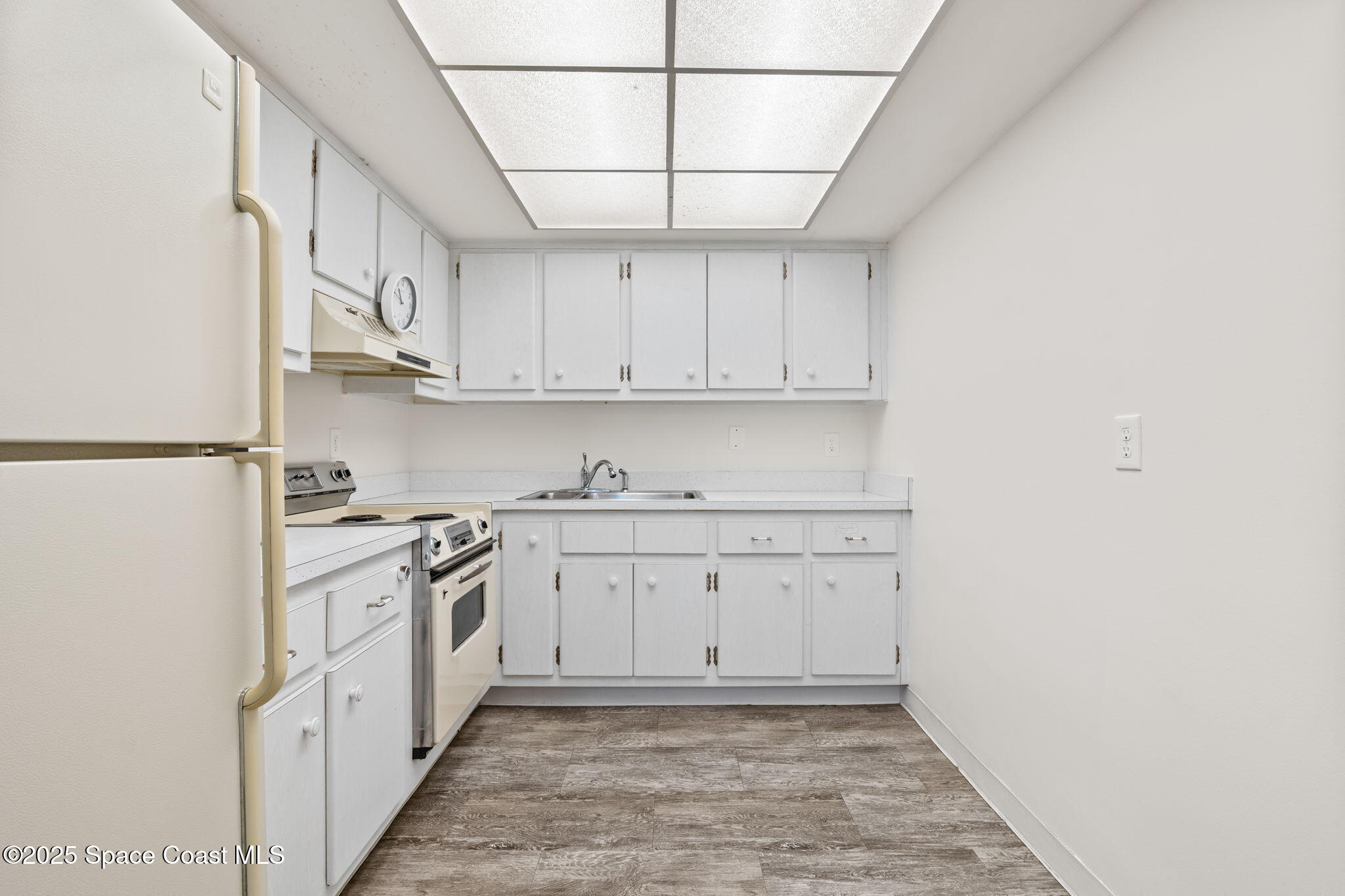221 Columbia Drive, Unit 343 Cape Canaveral, FL 32920 - Photo 13 of 22 a kitchen with granite countertop white cabinets and white appliances