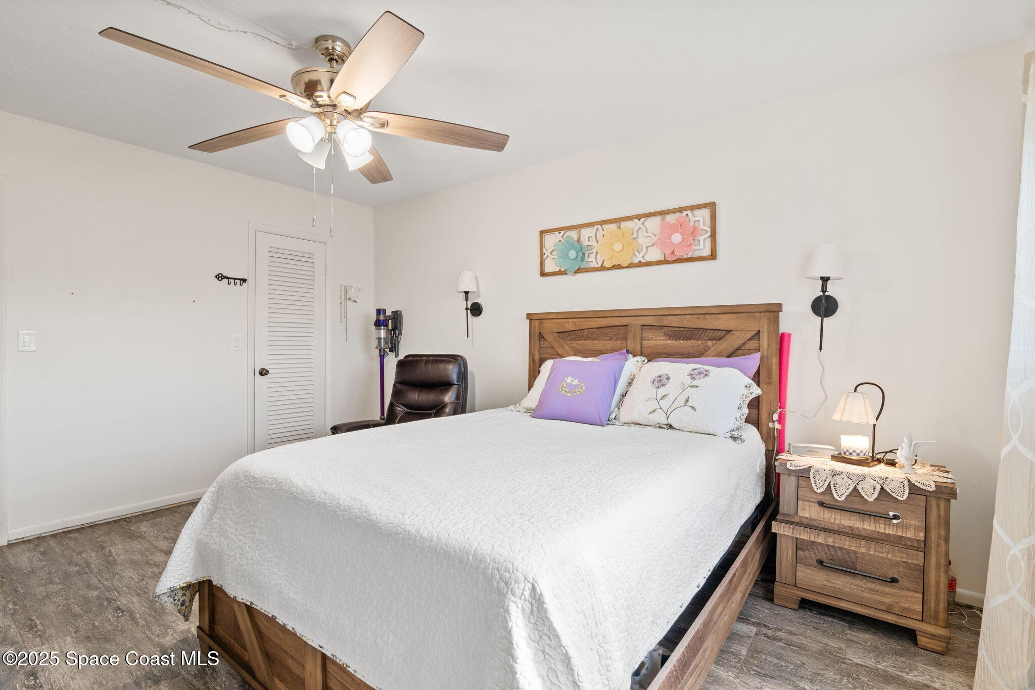 221 Columbia Drive, Unit 343 Cape Canaveral, FL 32920 - Photo 14 of 22 a bedroom with a bed and a chandelier