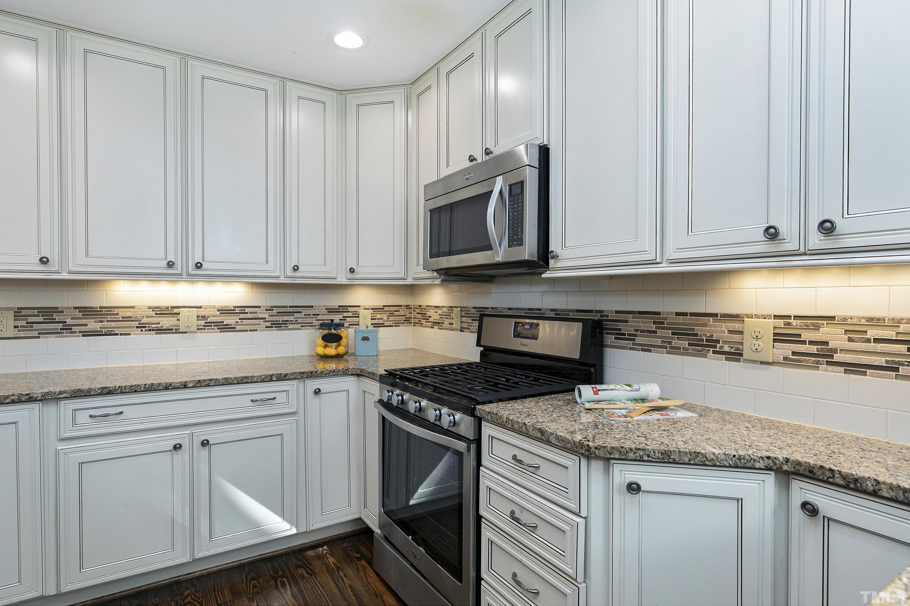 411 Dixie Trail Raleigh, NC 27607 - Photo 8 of 38 a kitchen with granite countertop white cabinets and stainless steel appliances