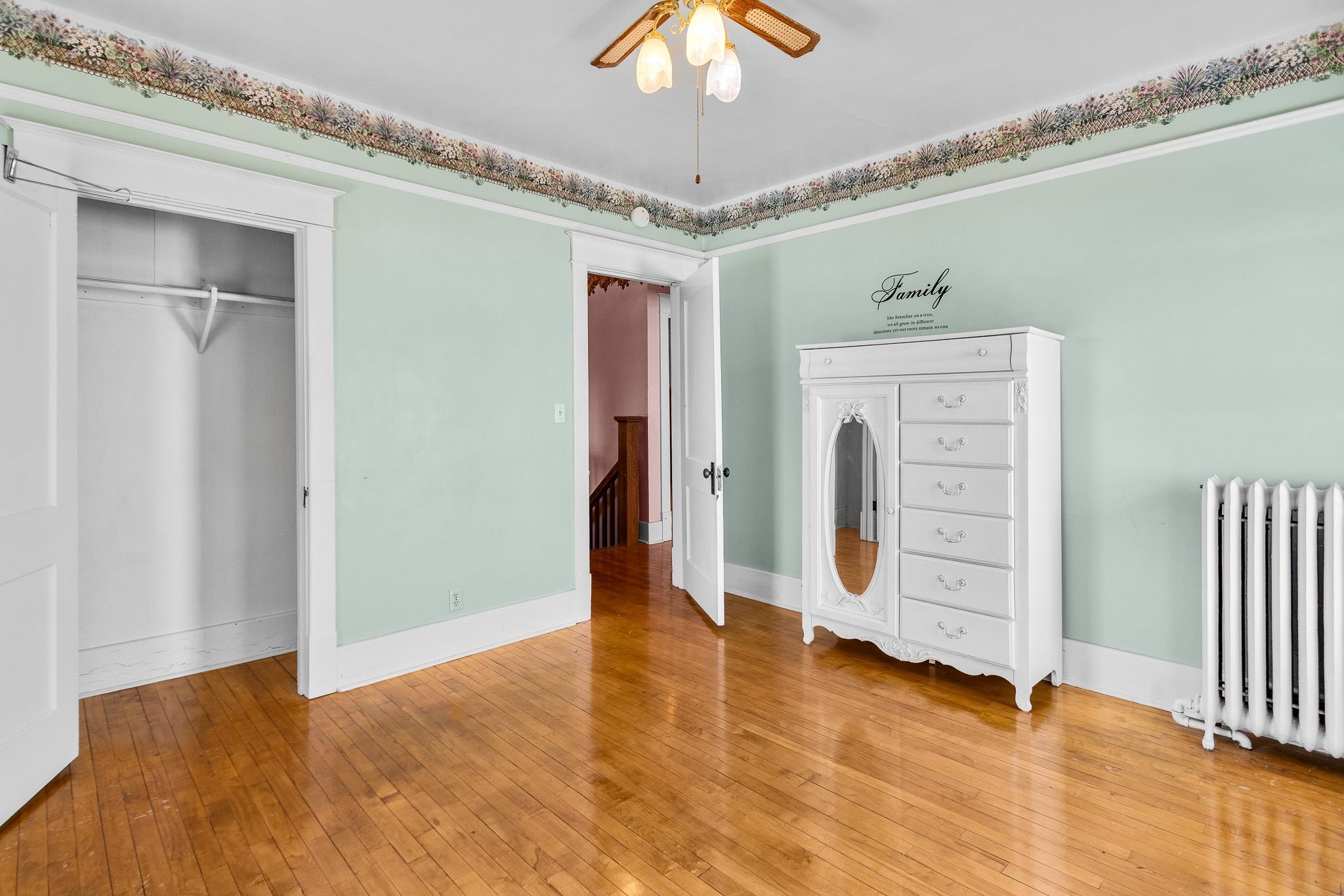 6494 School Street Finlayson, MN 55735 - Photo 15 of 32 Unfurnished bedroom featuring radiator heating unit, hardwood / wood-style flooring, and a closet