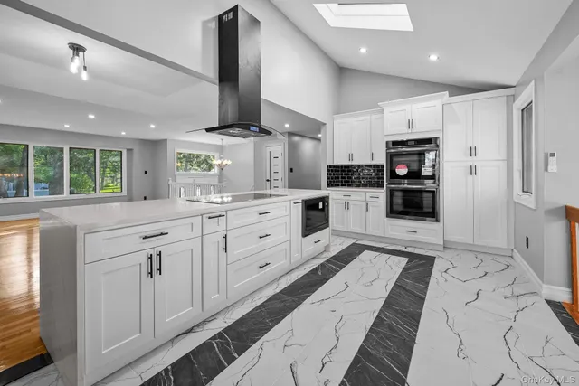 a kitchen with stainless steel appliances kitchen island granite countertop a refrigerator and a sink