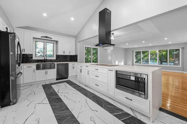 a kitchen with stainless steel appliances kitchen island granite countertop a stove a sink and a refrigerator