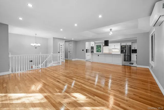 a large space with stainless steel appliances kitchen island a large counter top a sink and a refrigerator