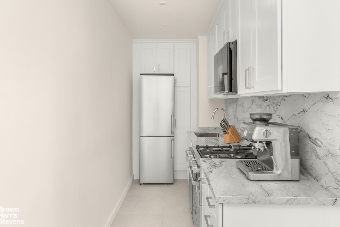 211 East 18th Street, Unit 3R Manhattan, NY 10003 - Photo 6 of 10 a kitchen with stainless steel appliances granite countertop a refrigerator sink stove and cabinets