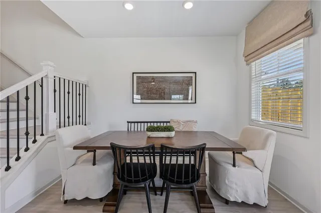 a kitchen with stainless steel appliances granite countertop a dining table chairs refrigerator and microwave