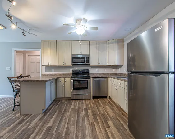 a kitchen with a refrigerator and a stove top oven