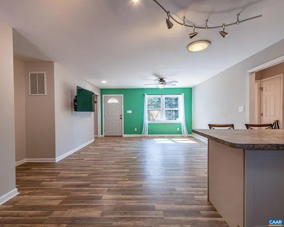 a view of an empty room with window and wooden floor