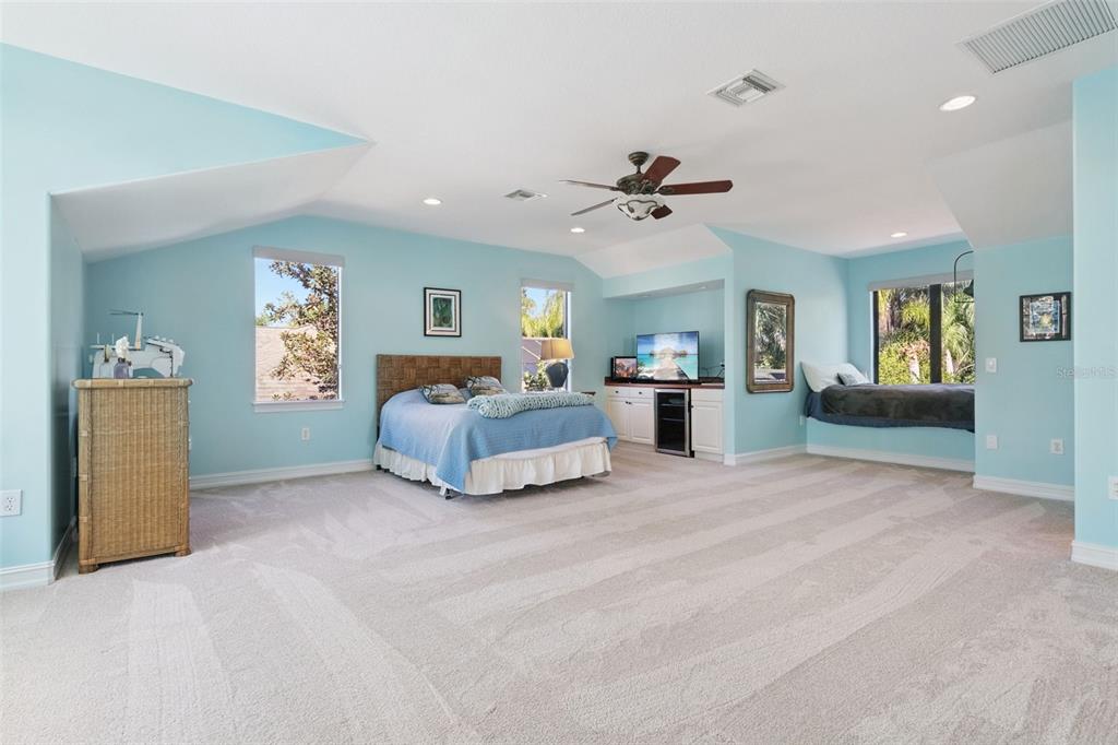 799 Oak Shadows Road Celebration, FL 34747 - Photo 30 of 97 a spacious bedroom with a large bed and a chandelier