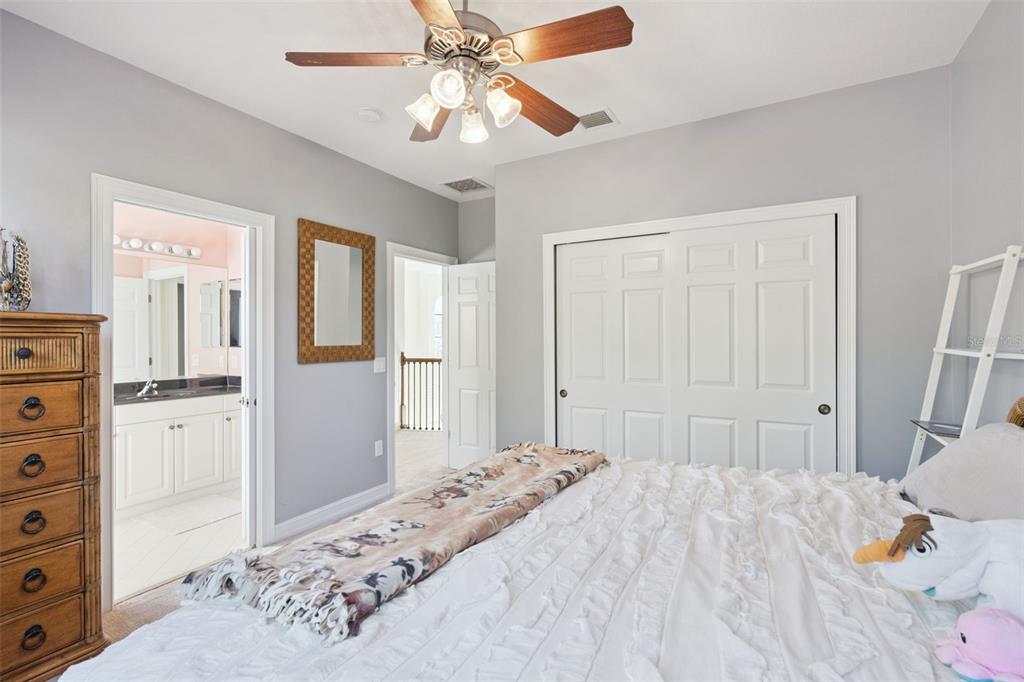 799 Oak Shadows Road Celebration, FL 34747 - Photo 35 of 97 a bedroom with a bed and a chandelier