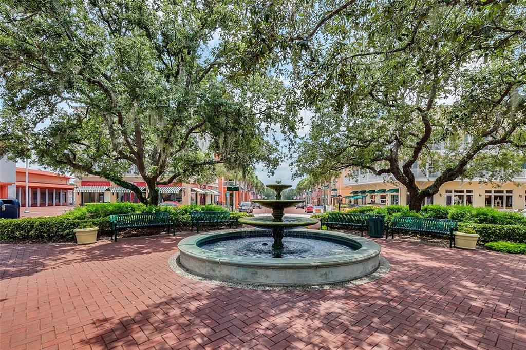 799 Oak Shadows Road Celebration, FL 34747 - Photo 62 of 97 a view of a fountain in front of a brick house with large trees