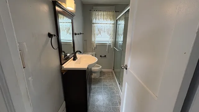 a bathroom with a sink a toilet and shower