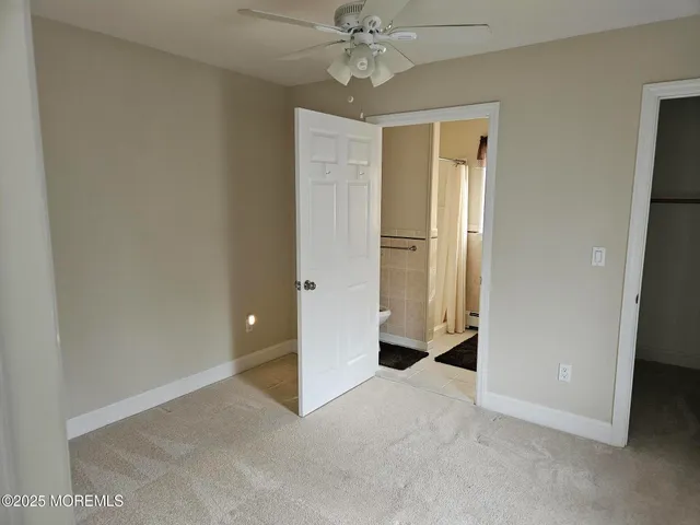 a view of an empty room with a ceiling fan