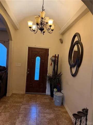 a view of a hallway with entryway and chandelier