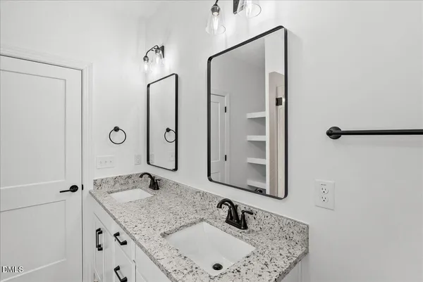 a bathroom with a granite countertop sink toilet and mirror