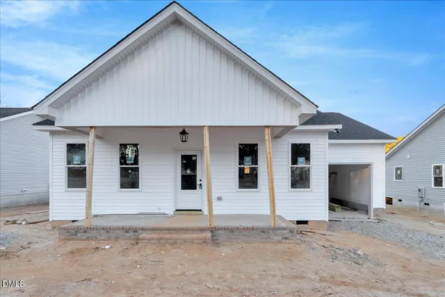 a front view of a house with white fence