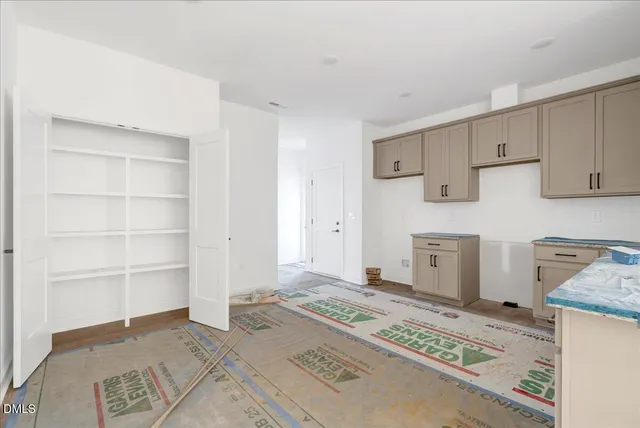 a view of a kitchen with refrigerator and cabinets