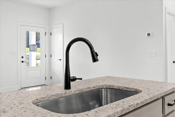 a kitchen with sink a microwave and cabinets