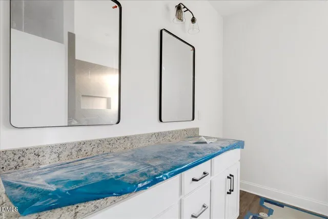 a bathroom with a granite countertop sink and a mirror