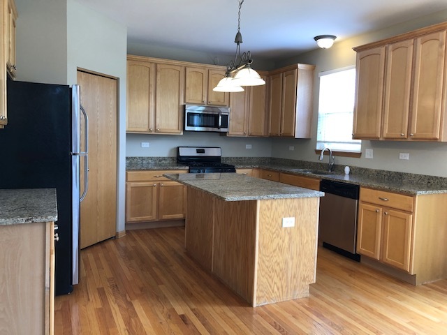 2845 Berman Road North Aurora, IL 60542 - Photo 11 of 23 a kitchen with kitchen island granite countertop a sink cabinets and stainless steel appliances