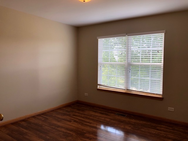2845 Berman Road North Aurora, IL 60542 - Photo 13 of 23 a view of an empty room with wooden floor and a window