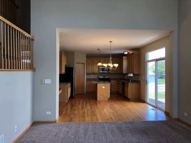 2845 Berman Road North Aurora, IL 60542 - Photo 9 of 23 a kitchen with stainless steel appliances kitchen island granite countertop wooden floors and view of living room