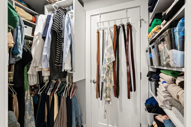 a view of walk in closet with clothes and shoes