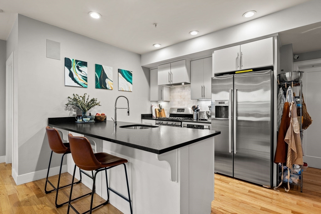 339 West Broadway, Unit 12 Boston, MA 02127 - Photo 2 of 23 a kitchen with kitchen island a counter top space cabinets and stainless steel appliances