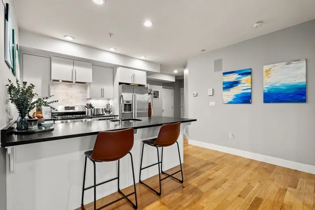 a kitchen with stainless steel appliances granite countertop a refrigerator and a stove top oven