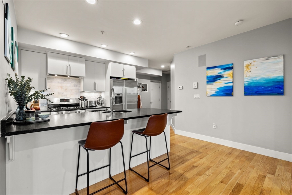 339 West Broadway, Unit 12 Boston, MA 02127 - Photo 3 of 23 a kitchen with stainless steel appliances granite countertop a refrigerator and a stove top oven