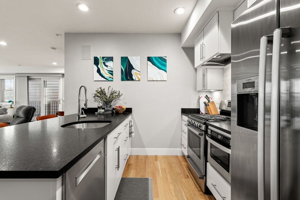 339 West Broadway, Unit 12 Boston, MA 02127 - Photo 4 of 23 a kitchen with stainless steel appliances a sink a stove and refrigerator