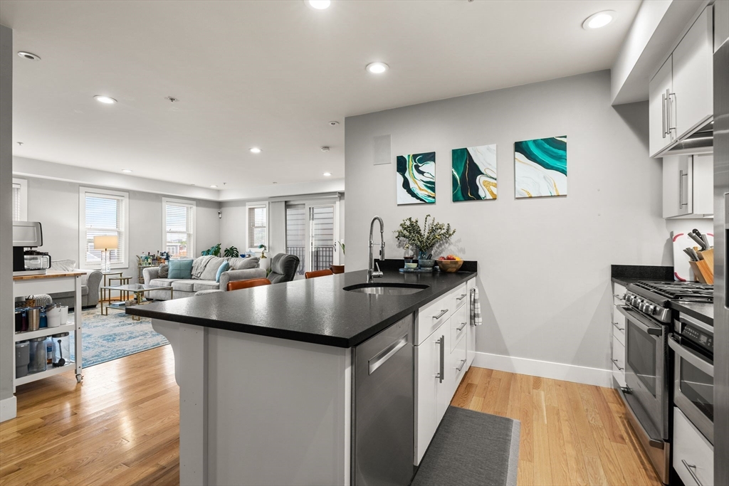 339 West Broadway, Unit 12 Boston, MA 02127 - Photo 5 of 23 a kitchen with stainless steel appliances granite countertop a sink a stove and a wooden floors