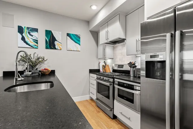 a kitchen with stainless steel appliances a stove a sink and a refrigerator