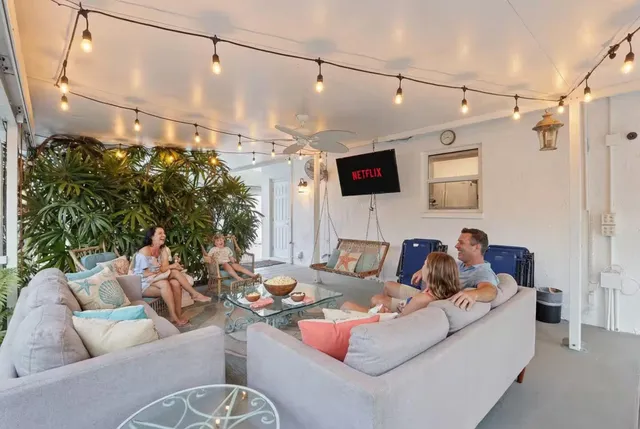 a living room with patio furniture and a large window