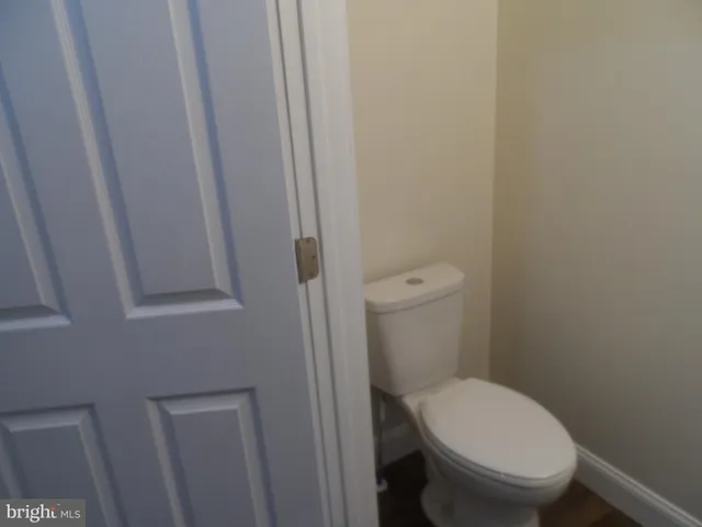 a white toilet sitting next to a small window