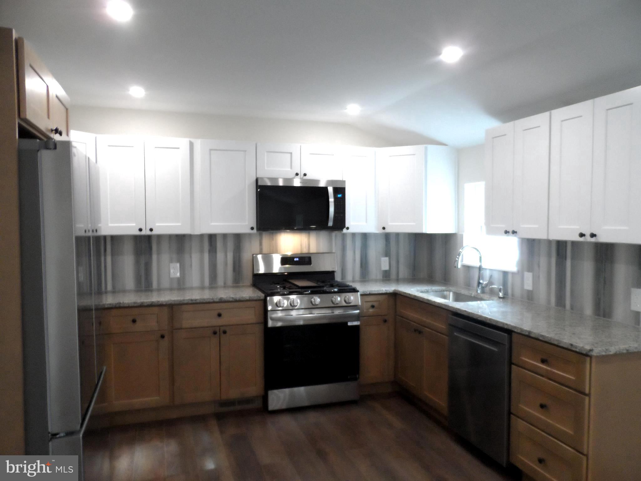 1335 Nottingham Way Hamilton, NJ 08609 - Photo 14 of 40 a kitchen with a sink a stove and cabinets