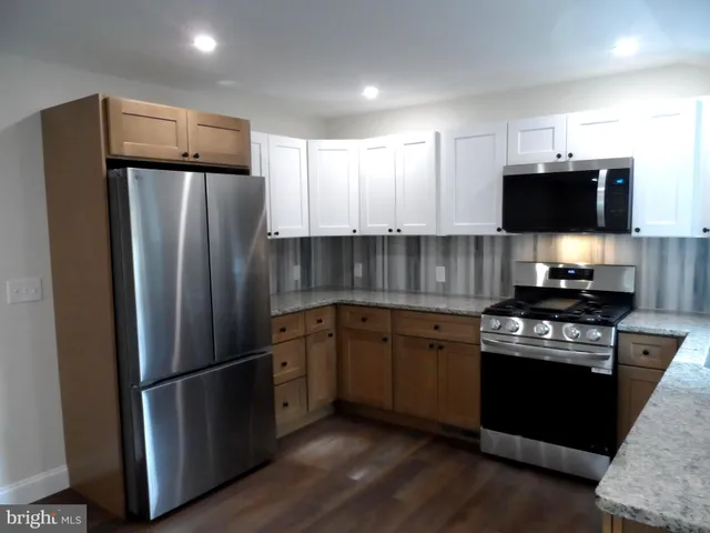 a kitchen with stainless steel appliances granite countertop a refrigerator stove and microwave