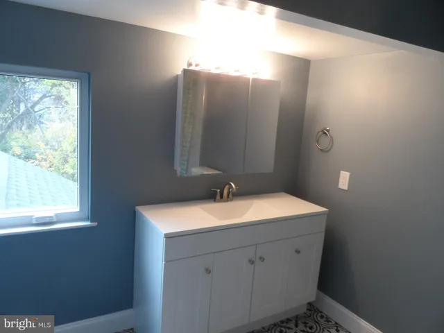 a bathroom with a sink vanity granite and a mirror
