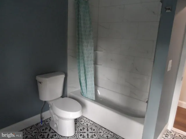 a white toilet sitting next to a shower