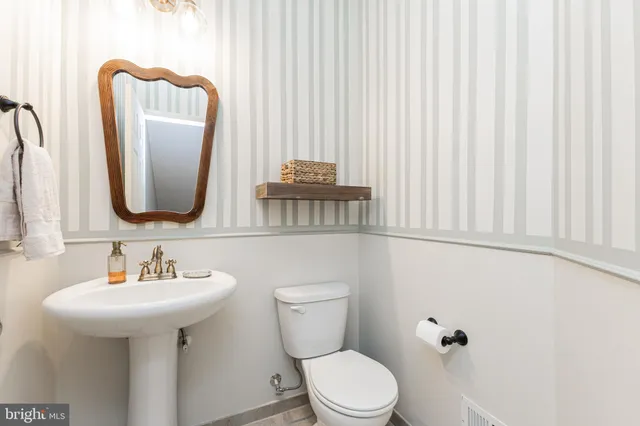 a bathroom with a toilet sink and mirror