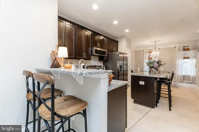 a kitchen with a dining table chairs and refrigerator