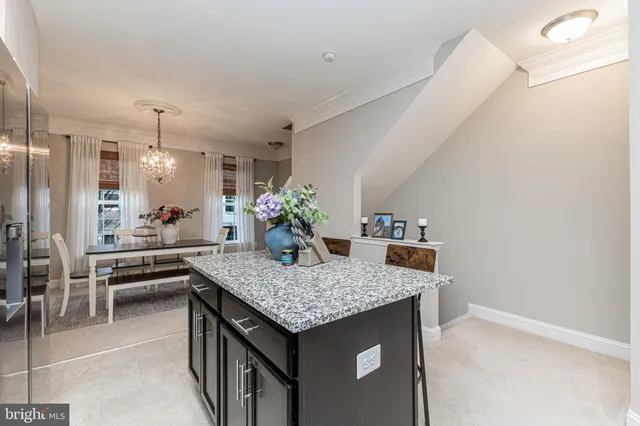 a dining hall with granite countertop a sink dishwasher a dining table and chairs with wooden floor