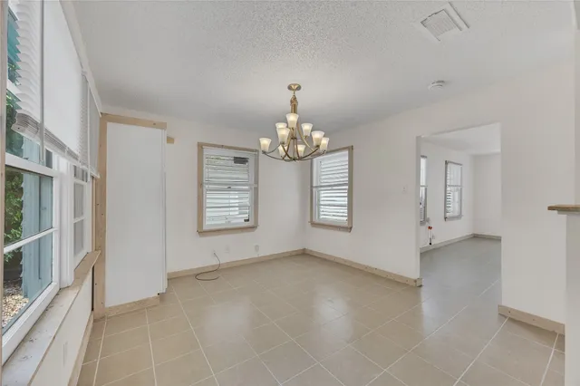 an empty room with windows and chandelier