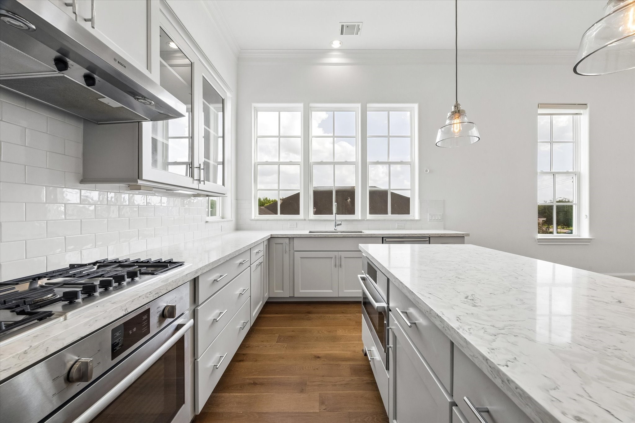 2024 Waterloo Station Road Houston, TX 77045 - Photo 3 of 19 The Kitchen has 42 inch cabinets with undercabinet lighting highlighting the neutral upgraded backsplash. Outlets are hidden underneath the cabinets, leaving the elegant backsplash uninterrupted.