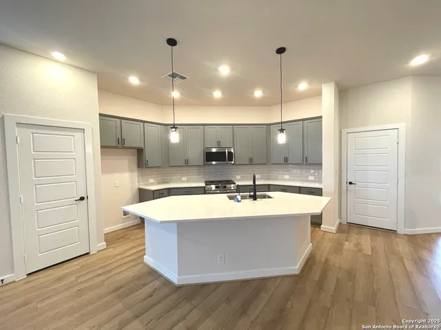 a large kitchen with kitchen island a sink a stove and a refrigerator